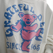 "Close-up of 'Grateful Dead 1965' collegiate-style lettering on white sweatshirt