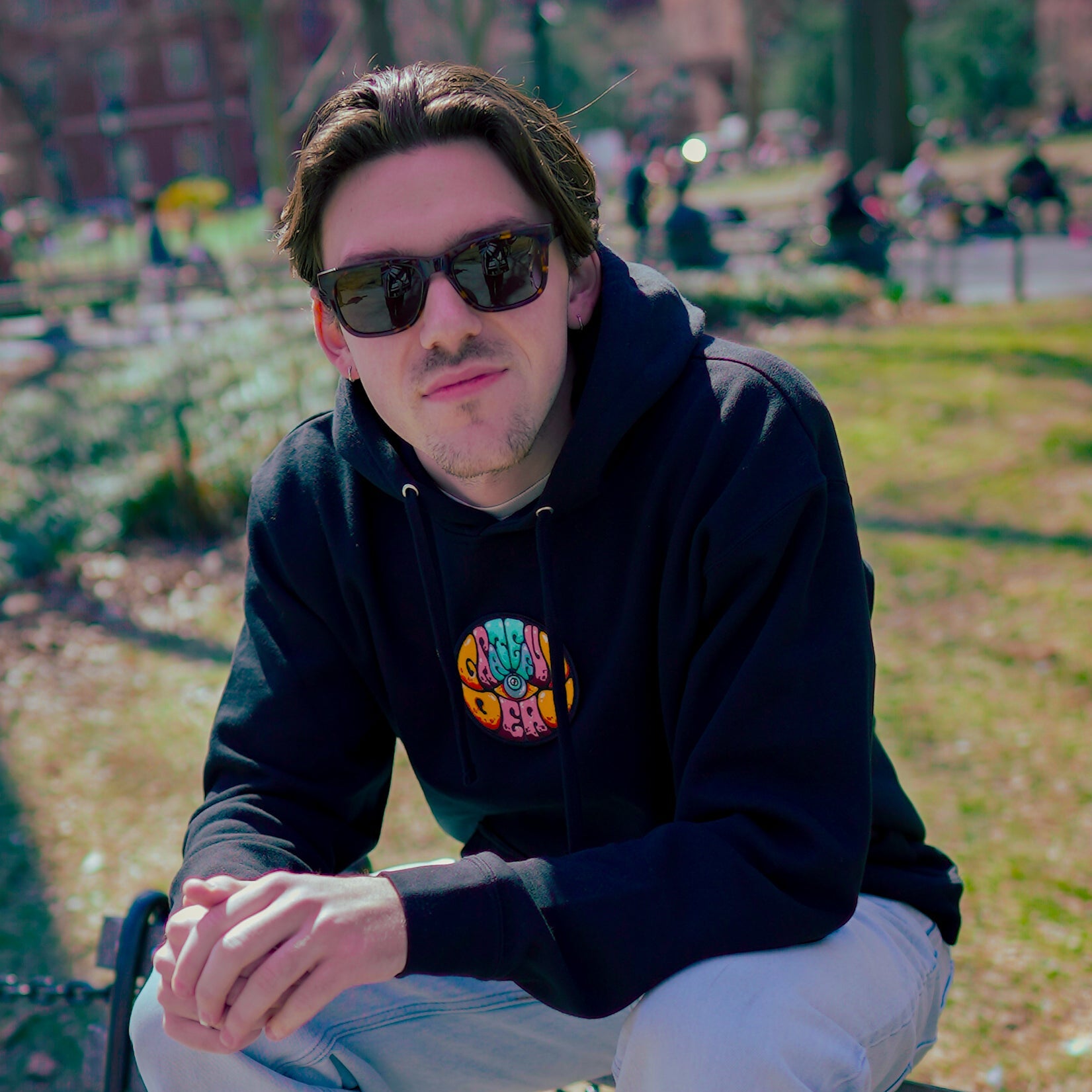 Model wearing Grateful Dead hoodie by Drew Millward while walking outdoors, showcasing the detailed front artwork in a real-world setting