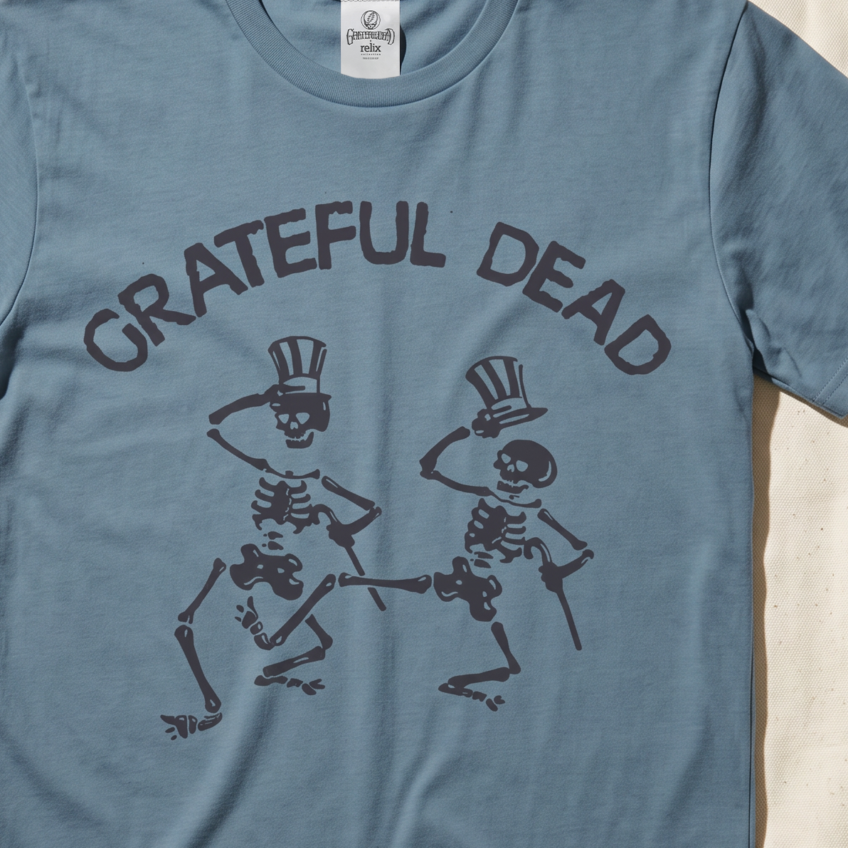 Close-up of the Dancing Skeletons print on an ice blue t-shirt