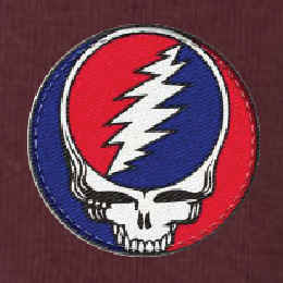 Close-up of the embroidered Stealie patch on a maroon thermal long-sleeve t-shirt