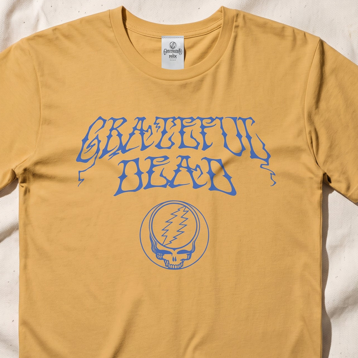 Close-up of the Stealie Logo print on a mustard t-shirt