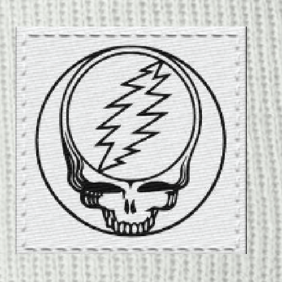 Close-up of the woven Stealie label on a white cuffed beanie