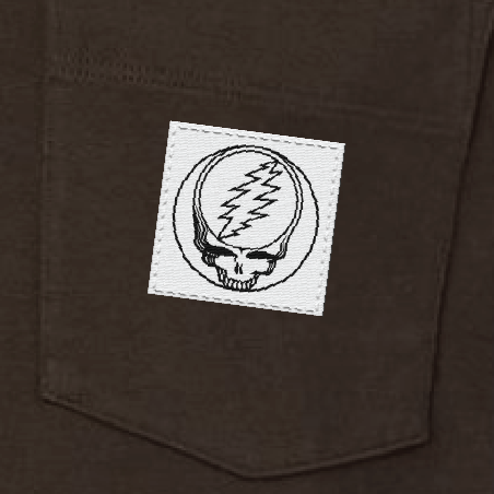 Close-up of the woven Stealie label on the pocket of a brown long-sleeve t-shirt