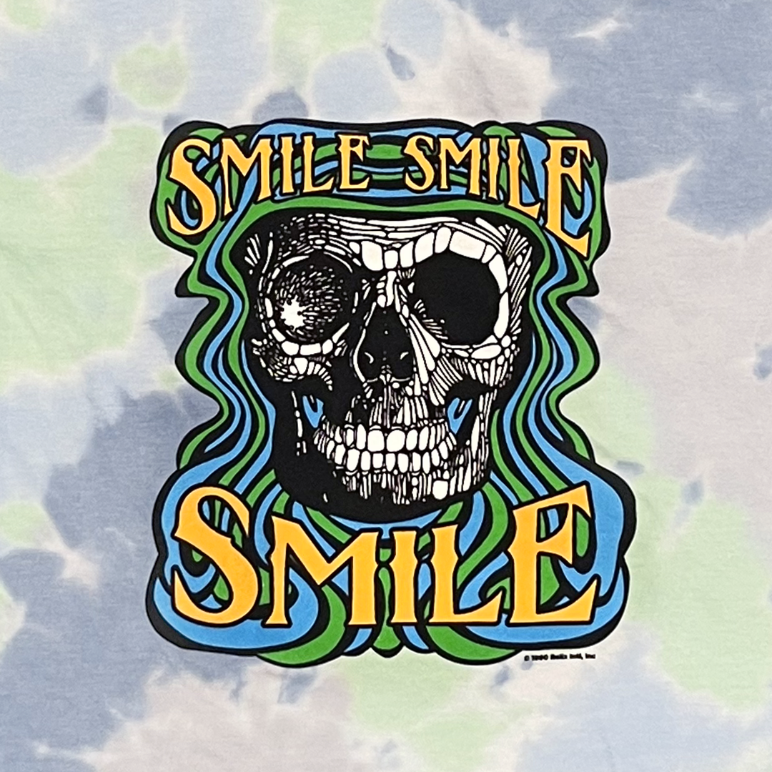 Close-up of retro-style Smile Smile Smile smiley face graphic on tie-dye t-shirt